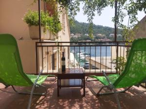 - deux chaises vertes et une table sur un balcon avec vue dans l'établissement Apartment Nela, à Brna