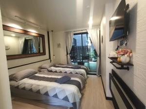 2 Betten in einem Zimmer mit Spiegel in der Unterkunft Rangyen Homestay Cha-Am รังเย็น in Cha-am