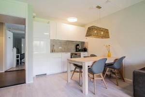 cocina y comedor con mesa y sillas en Beach Appartement 10 - Callantsoog, en Callantsoog