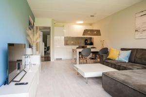 a living room with a couch and a table at Beach Appartement 10 - Callantsoog in Callantsoog