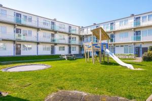 een speeltuin voor een groot appartementencomplex bij Beach Appartement 10 - Aan de duinen, Callantsoog aan Zee in Callantsoog