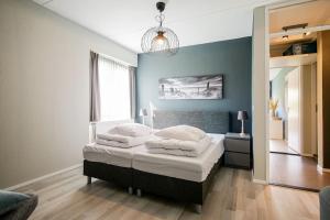 een slaapkamer met 2 bedden en een blauwe muur bij Beach Appartement 10 - Aan de duinen, Callantsoog aan Zee in Callantsoog