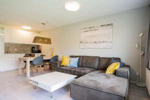 a living room with a couch and a table at Beach Appartement 10 - Callantsoog in Callantsoog