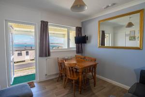 a dining room with a table and chairs and a mirror at Kipling Villa With Sea Views in Bideford