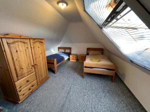 a attic room with a bed and a bedroom with a window at Landhaus am Teich in Lohmen