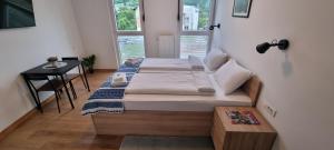 1 dormitorio con 2 camas, mesa y ventana en Pansion Hukić B&B en Tuzla