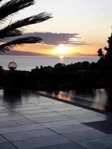a sunset over the ocean with the sun setting at Villa Faihs in Afissos