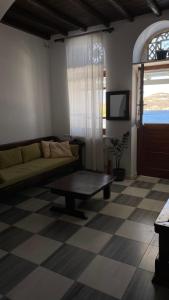 a living room with a couch and a table at Planitis Lighthouse View in Panormos