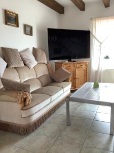 ein Wohnzimmer mit einem Sofa und einem Flachbild-TV in der Unterkunft HAusZeit Kapitänshaus Friedrichsschleuse in Carolinensiel