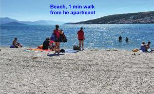 eine Gruppe von Menschen an einem Strand mit den Worten Strand min Fußweg von in der Unterkunft Beachfront apartments Jurica with balcony in Trogir