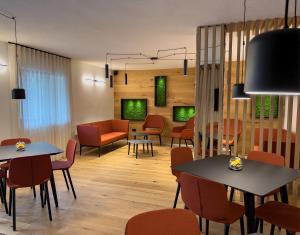 ein Wohnzimmer mit Tischen und Stühlen und ein Esszimmer in der Unterkunft Hotel Fantelli in Folgarida