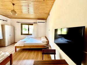 a bedroom with a bed and a flat screen tv at Incekum Pansiyon in Bodrum City