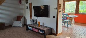 un soggiorno con TV a schermo piatto a parete di "La casetta" indipendente, con ampio spazio verde a Fontechiari
