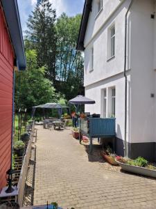 a brick walkway next to a white building with umbrellas at Eulennest bis 10 Personen,Wäsche,Reinigung,Parkplatz inklusive,Kurtaxe wird extra berechnet in Altenau