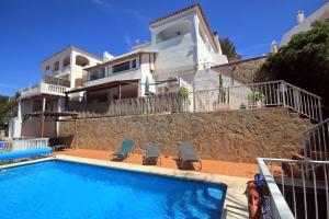 a house with a swimming pool in front of a house at Casa Dieter-air conditioning is not included in Cala Galdana