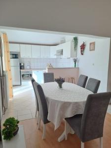 - une cuisine et une salle à manger avec une table et des chaises dans l'établissement Apartment Ema, à Posedarje