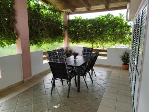 een tafel en stoelen op een patio met bomen bij Apartment Ema in Posedarje