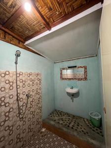a bathroom with a shower and a sink in it at Asim Paris Guesthouse in Bukit Lawang