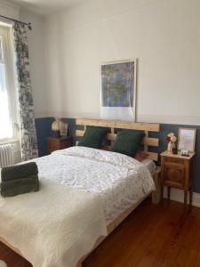 a bedroom with a large bed with green pillows at La Maison du Markstein in Linthal