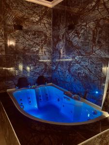 a blue tub in a room with a stone wall at Aysultan Stone House in Uchisar
