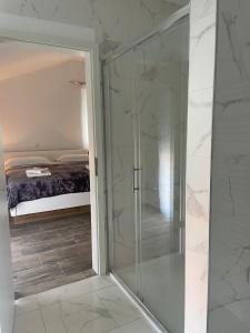 - une douche en verre dans une chambre avec un lit dans l'établissement Apartments Ružica Zadar, à Zadar