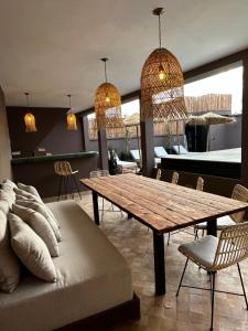 a dining room with a wooden table and chairs at Riad Belharra in Marrakech