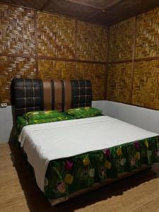 a large bed in a room with at Asim Paris Guesthouse in Bukit Lawang