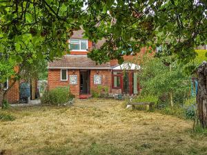 uma casa de tijolos com um banco no quintal em Chilbolton em Chilbolton