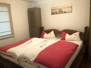 a bedroom with a bed with a red and white blanket at Richtberg 2 in Plau am See