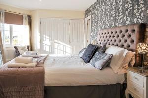 1 dormitorio con 1 cama grande y cabecero acolchado en Windrush Lake 80 & 81, Waterlow Lodge P, en South Cerney
