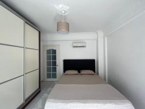 1 dormitorio con 1 cama en una habitación blanca en Göle Manzaralı Bahçeli Havuzlu, en Koycegiz