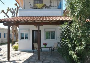 a patio with a table and chairs in front of a house at Apartments Xara in Velika