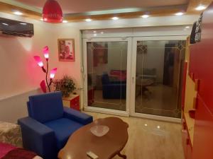 a living room with a blue chair and a table at Hacijenda Vidikovac in Šabac +34 photos