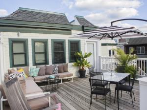 un patio con mesa, sillas y sombrilla en ZEY HOTEL, en Greenport