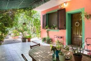 een patio met een tafel en stoelen en een huis bij Le Calle in Iglesias