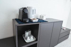 a small grey cabinet with a coffee maker on it at Casa Valentina in Senigallia