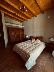 1 dormitorio con cama grande y techo de madera en Don Segundo, en Lobos 20 fotos más