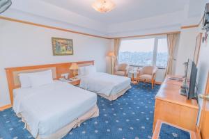 ein Hotelzimmer mit 2 Betten und einem TV in der Unterkunft A25 Luxury Hotel in Hanoi