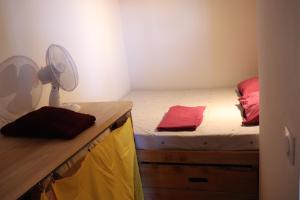 a bedroom with a bed and a desk with a fan at Nestudio : studio pour 2 / 3 personnes in Saint-Laurent-de-Neste