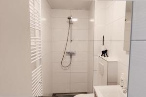 een badkamer met een douche, een toilet en een wastafel bij Beach Appartement 17 - Callantsoog in Callantsoog