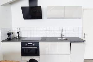 a kitchen with a sink and a stove at Beach Appartement 17 - Aan de duinen, Callantsoog aan Zee in Callantsoog +13 photos
