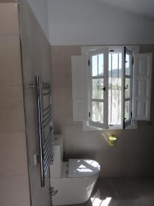 łazienka z toaletą i oknem w obiekcie Finca Flor w mieście Canillas de Albaida