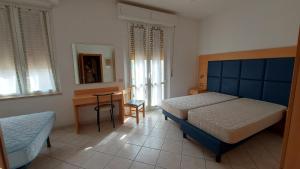 サン·ヴィンチェンツォにあるCasa Vacanze Principessaのベッドルーム1室(ベッド2台、テーブル、椅子付)