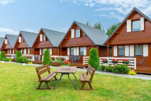 a group of houses with a picnic table in the yard at Domki Relax in Ustka