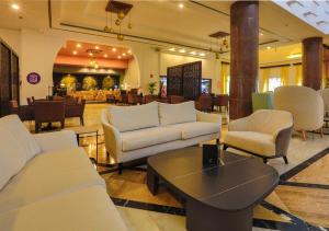 eine Lobby mit Sofas, einem Tisch und einem Restaurant in der Unterkunft Be Live Collection Saïdia in Saidia 