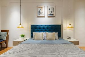 a bed with a blue headboard in a bedroom at VietHOME Trang Tien in Hanoi