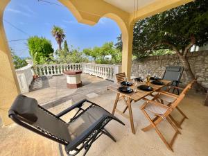 Un patio con dos sillas y una mesa y una sombrilla. en Kuća za odmor Fay, en Dramalj