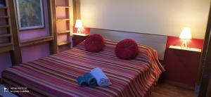 ein Schlafzimmer mit einem Bett mit roten Garnbällen darauf in der Unterkunft Anirbas in Reggio di Calabria