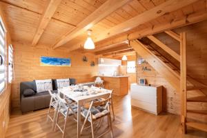a dining room and kitchen in a log cabin with a table and chairs at Domki Relax in Ustka