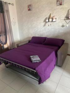 a bedroom with a purple bed with a purple sheets at Casa Marsala in Olbia